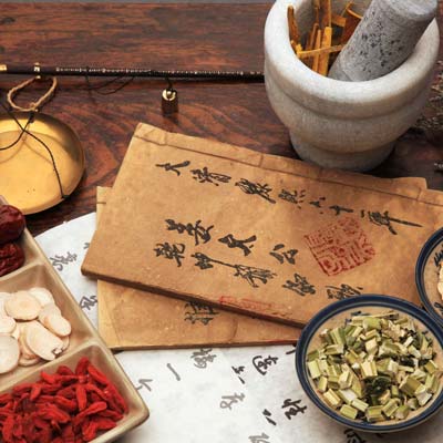 Oriental medicine writing with chinese herbs and mortar and pestle.