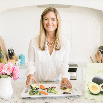 Kathryn Flynn in a kitchen smiling and preparing food for fertility care